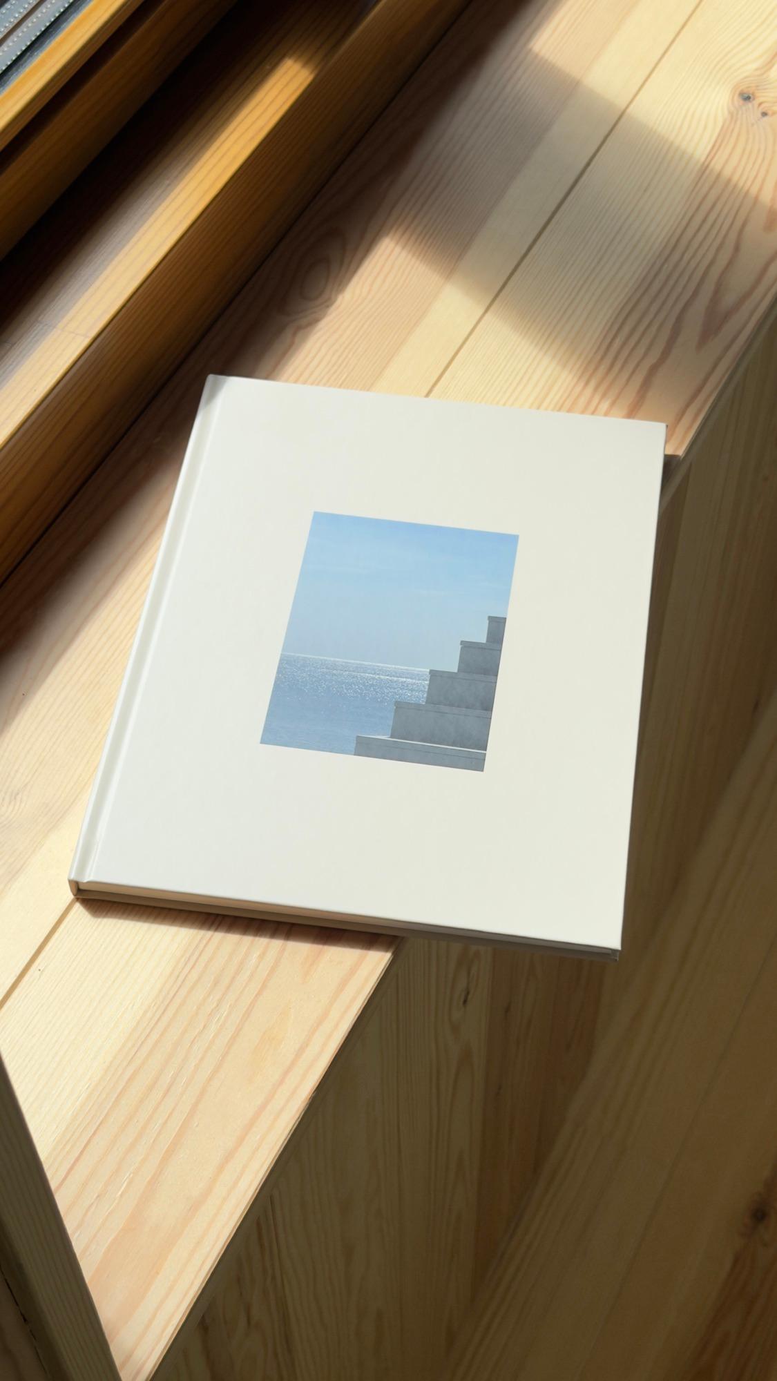 Een fotoboek van foto foto op een houten vensterbank in de zon