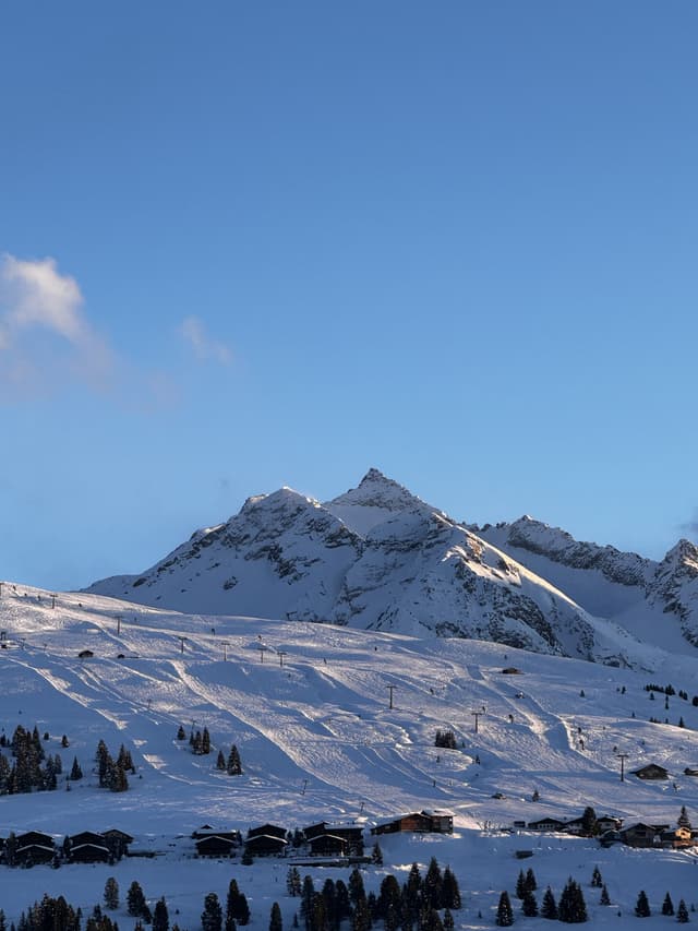 Een besneeuwde bergtop onder een bleke lucht